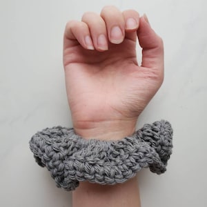 May include: A gray crocheted hair scrunchie.