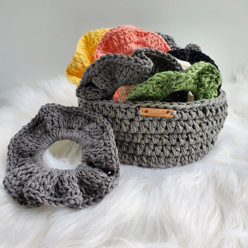 May include: A gray crocheted basket with a wooden tag that says "The Little Things" filled with colorful crocheted rings.