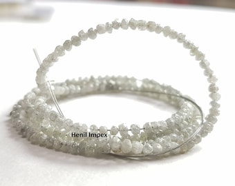 May include: A strand of rough, white diamond beads. The beads are small and irregular in shape, and they are strung on a thin wire. The beads are arranged in a circle, and they are all of the same size. The beads are white and have a slightly cloudy appearance. The beads are strung on a thin wire, and they are all of the same size. The beads are white and have a slightly cloudy appearance. The text "Henil Impex" is visible on the image.
