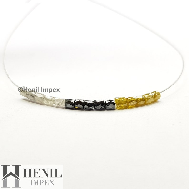 May include: A necklace featuring white, black, and yellow diamond beads. The beads are strung on a clear thread. The necklace is displayed against a white background. &copy;Henil Impex