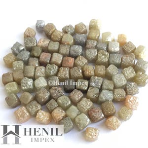 May include: A collection of small, rough, cubic diamonds in various shades of brown, grey, and white. © Henil Impex