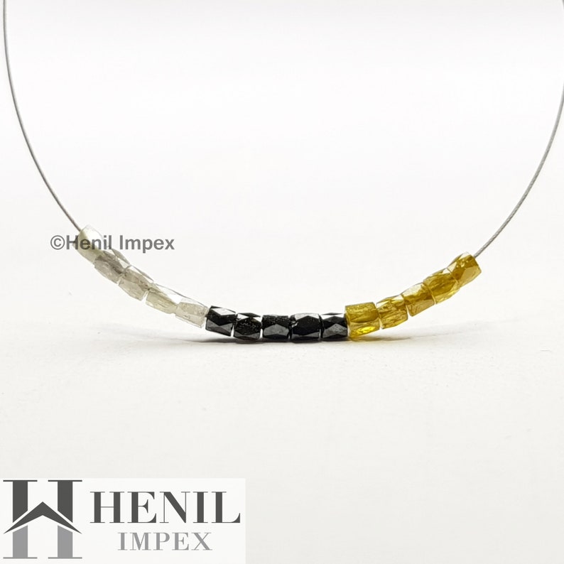 May include: A strand of beads made of white, black, and yellow diamonds. The beads are strung on a thin wire. The image includes the text "Henil Impex".