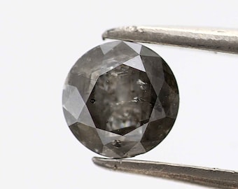 May include: A round, gray diamond with a faceted cut. The diamond is held by tweezers.