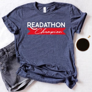 May include: A navy blue t-shirt with the text "READATHON Champion" in white letters on a red banner.