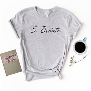 Puede incluir: Camiseta gris con el texto "E. Bront&euml;" en letra cursiva negra.