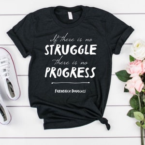 Może przedstawiać: Czarny T-shirt z białym tekstem, który brzmi "If there is no struggle there is no progress" i "Frederick Douglass" poniżej.