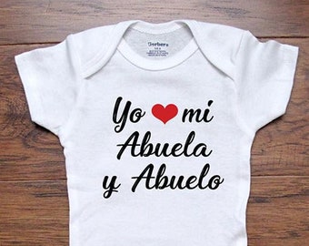 May include: White baby onesie with black text that reads "Yo mi Abuela y Abuelo" with a red heart between "Yo" and "mi".