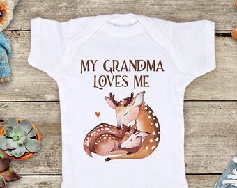 May include: White baby onesie with a brown deer and fawn illustration. The onesie has the text "My Grandma Loves Me" printed on it.