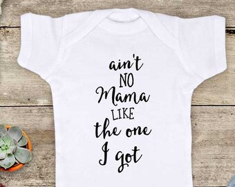 May include: White baby onesie with black text that reads "ain't no mama like the one I got".