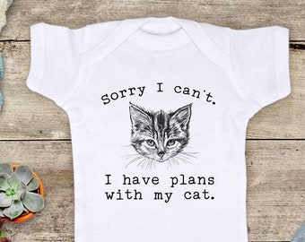 May include: White baby onesie with a black and white illustration of a cat and the text "Sorry I can't. I have plans with my cat."