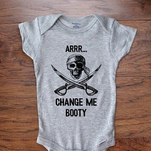 May include: Gray baby onesie with a black and white skull and crossbones design. The text "ARRR... CHANGE ME BOOTY" is printed on the onesie.
