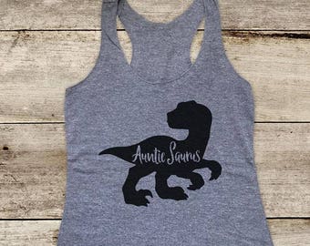 May include: A heather gray racerback tank top with a black dinosaur graphic and the text "Auntie Saurus". The tank top is made of a soft material and is suitable for casual wear.