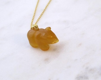 May include: A gold chain necklace with a small, amber-colored bear pendant.