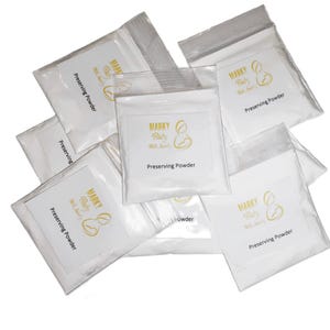 May include: Six white pouches with gold lettering that reads "MARKY Baby Milk Saver" and "Preserving Powder".