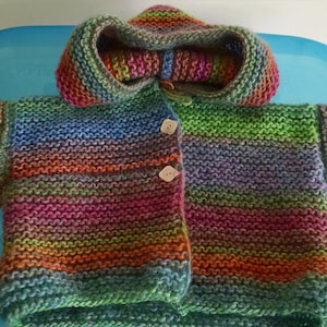 Baby hand knit sweater with hood in multiple colors and various sizes.