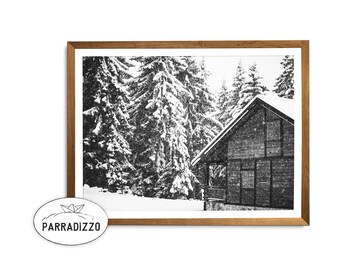 Könnte beinhalten: Schwarz-Weiß-Druck in einem Rahmen mit einem verschneiten Blockhaus inmitten von schneebedeckten Tannen. Der Druck befindet sich in einem Naturholzrahmen. Das Parradizzo-Logo befindet sich unten links.