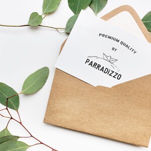 May include: A white card with the text "PREMIUM QUALITY BY PARRADIZZO" and a small illustration of a paper boat on a wave. The card is in a brown envelope.