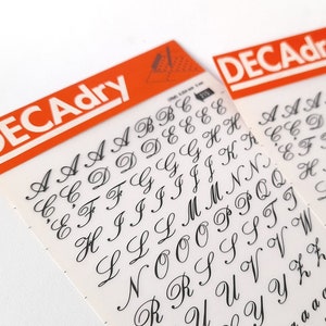Set vintage di due trasferibili con sfregamento istantaneo su lettere di Decadry. Stencil di lettere d'epoca. Grafica d'epoca.