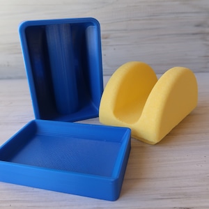 May include: Three 3D printed storage containers. One is yellow and shaped like a half-circle. The other two are blue and rectangular.