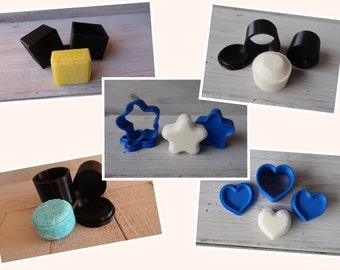 Puede incluir: Un conjunto de tres recipientes de plástico negro con tapas, una barra de jabón amarilla, un molde de jabón en forma de estrella azul, una barra de jabón blanca en forma de estrella, un molde de jabón en forma de corazón azul, una barra de jabón blanca en forma de corazón y un molde de jabón redondo azul.