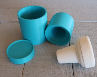 May include: A set of three turquoise blue plastic molds for making candles. The molds are cylindrical and have a smooth finish. The set includes a tall cylinder, a shorter cylinder, and a cone-shaped mold.