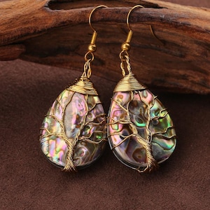 May include: A pair of teardrop-shaped earrings featuring iridescent abalone shell cabochons wrapped in gold-toned wire. The wire is intricately coiled to form a tree-like design over the surface of each shell, suspended from gold-toned hooks.