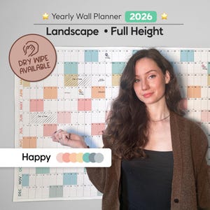 May include: A 2026 yearly wall planner in landscape format. The full-height calendar has a dry-wipe surface. It features a colorful design with pastel boxes for each day. The text "Happy" is visible on the planner.
