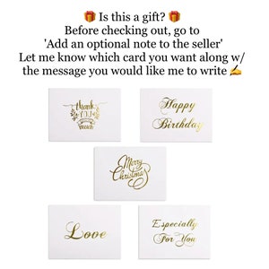 以下が含まれることがあります： 金色の文字が書かれた白いカードが5枚。カードには、「ありがとう」、「愛」、「メリークリスマス」、「お誕生日おめでとう」、「あなただけに」というメッセージが書かれています。