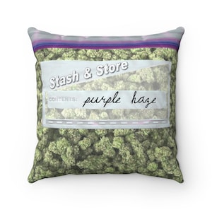 May include: Square pillow with a graphic of a clear bag filled with green buds. The bag has a white label with the words "Stash & Store" and "CONTENTS: purple haze" in a handwritten font.