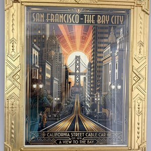 May include: A framed art print featuring a stylized San Francisco cityscape with the text SAN FRANCISCO-THE BAY CITY, CALIFORNIA STREET CABLE CAR, EST. 1878, and A VIEW TO THE BAY. The print is encased in an ornate, metallic gold-colored frame.
