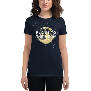 May include: Navy blue women's t-shirt with a gold moon graphic and the text "Fly me to the moon, let me play among the stars".