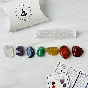 Pu&ograve; includere: Set di sette cristalli chakra, tra cui quarzo trasparente, ametista, sodalite, aventurina verde, citrino, corniola e diaspro rosso. I cristalli sono disposti a forma di arcobaleno su una superficie bianca. Sono inclusi anche una bacchetta di ricarica in selenite e una carta con informazioni sui chakra.