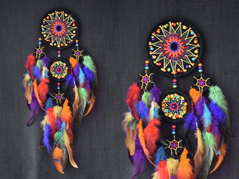 May include: Two colorful dreamcatchers with black felt circles and colorful feathers. The dreamcatchers have a starburst design in the center of each circle.