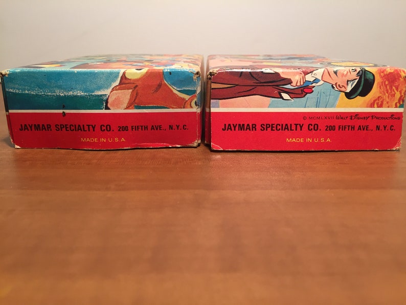 May include: Two red and white cardboard boxes with the text "JAYMAR SPECIALTY CO. 200 FIFTH AVE., N.Y.C. MADE IN U.S.A." printed on the bottom. The box on the right has the additional text "MCMLXVII Walt Disney Productions" printed on the bottom.