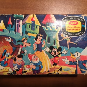 May include: A vintage Jaymar Bantam Pocket Walt Disney Character Picture Puzzle box featuring Mickey Mouse, Donald Duck, Goofy, Snow White, and Dopey. The box is blue with a yellow and red Jaymar logo and the text "Bantam Pocket Walt Disney Character Picture Puzzle".