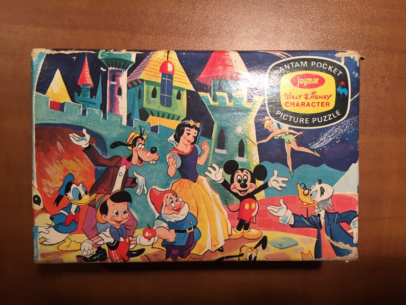 May include: A vintage Jaymar Bantam Pocket Walt Disney Character Picture Puzzle box featuring Mickey Mouse, Donald Duck, Goofy, Snow White, and Dopey. The box is blue with a yellow and red Jaymar logo and the text "Bantam Pocket Walt Disney Character Picture Puzzle".