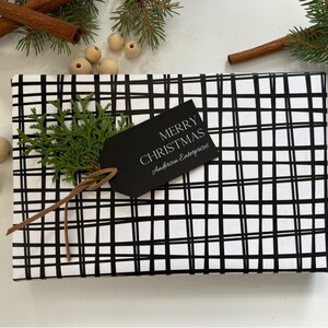 May include: Black and white plaid gift wrap with a black gift tag that says "Merry Christmas" and "Anderson Enterprises".