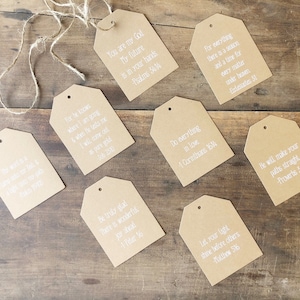 Pu&ograve; includere: Otto etichette regalo in carta marrone con testo bianco. Ogni etichetta ha un versetto biblico diverso stampato su di essa. Le etichette sono legate insieme con uno spago.