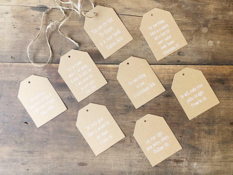 Pu&ograve; includere: Otto etichette regalo in carta marrone con testo bianco. Ogni etichetta ha un versetto biblico diverso stampato su di essa. Le etichette sono legate insieme con uno spago.