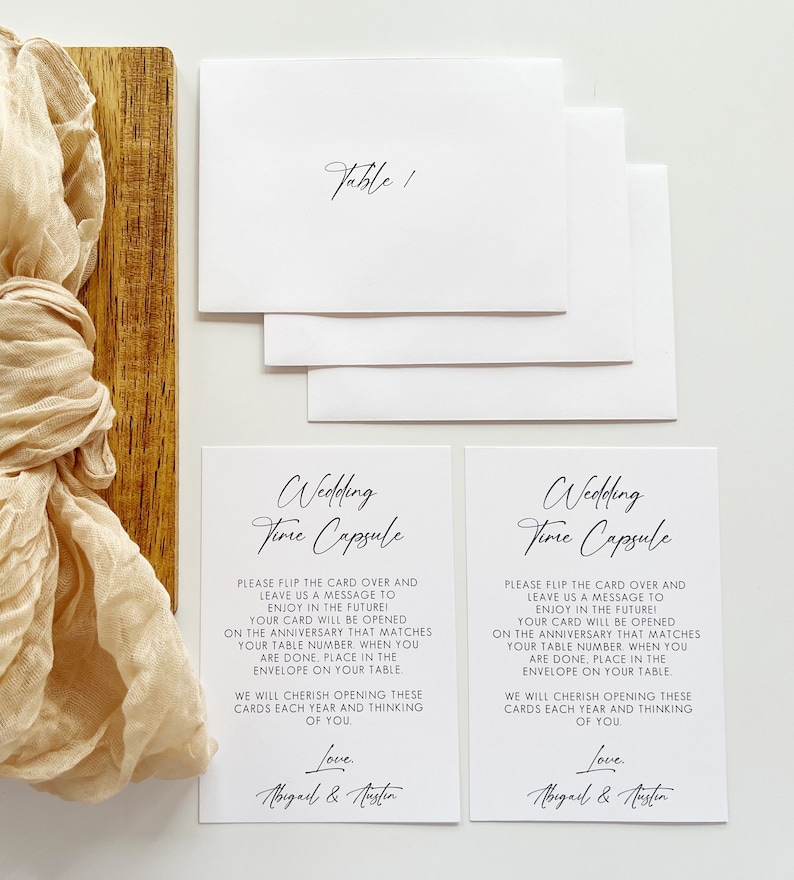 Puede incluir: Dos tarjetas blancas con texto negro que dicen "Wedding Time Capsule". Las tarjetas instruyen a los invitados a escribir un mensaje para la pareja que se abrir&aacute; en su aniversario. Las tarjetas est&aacute;n firmadas "Love, Abigail & Austin".