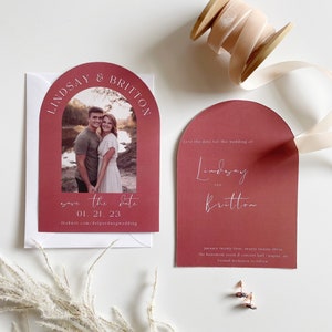 May include: Save the date card with a burgundy arch design. The card features a photo of a couple and the text "Save the date 01.21.23 theknot.com/delperdangwedding".