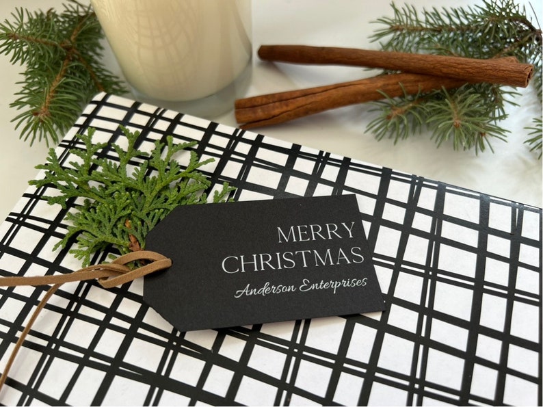 May include: A black and white plaid gift wrap with a black gift tag that says "Merry Christmas Anderson Enterprises".