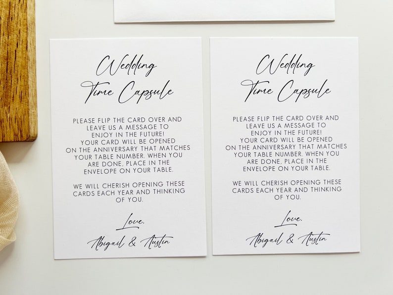Puede incluir: Dos tarjetas blancas con texto negro que dicen "Wedding Time Capsule". Las tarjetas instruyen a los invitados a escribir un mensaje para la pareja que se abrir&aacute; en su aniversario. Las tarjetas est&aacute;n firmadas "Love, Abigail & Austin".
