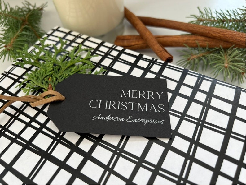 May include: Black and white plaid gift wrap with a black gift tag that says "Merry Christmas" and "Anderson Enterprises" in white text.