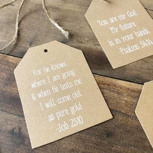 Pu&ograve; includere: Due etichette regalo di carta marrone con testo bianco. La prima etichetta dice "Perch&eacute; egli sa dove io vado, e quando mi metter&agrave; alla prova, ne uscir&ograve; come oro puro. -Giobbe 23:10". La seconda etichetta dice "Tu sei il mio Dio Il mio futuro &egrave; nelle tue mani. -Salmi 34:14".