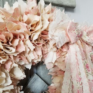 Puede incluir: Una corona de tela rosa y blanca con detalles de encaje y cinta. La corona est&aacute; hecha de recortes de tela y est&aacute; decorada con encaje y cinta rosa y blanca.