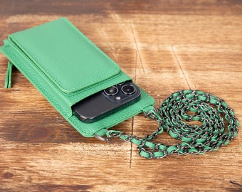 Puede incluir: Una funda de teléfono de cuero verde con un teléfono negro en el interior y una correa de cadena negra.
