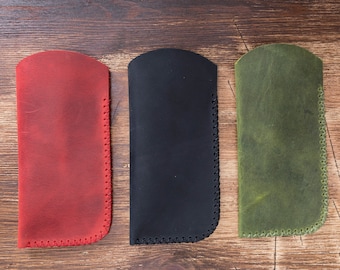May include: Three leather cases for glasses or other small items. The cases are red, black, and green.