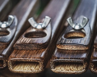 May include: Close-up of four wooden musical instruments with metal tuning knobs. The instruments are dark brown with a light brown wood grain pattern. Each instrument has a round hole in the center and a rectangular opening at the bottom.
