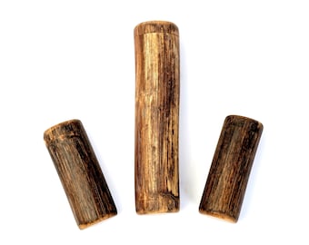May include: Three wooden cylinders of varying lengths, all with a dark brown finish and a slightly rough texture.